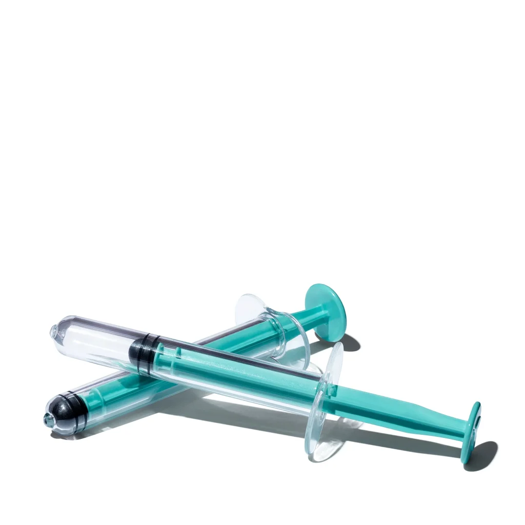 two teal and clear syringes positioned on a white background